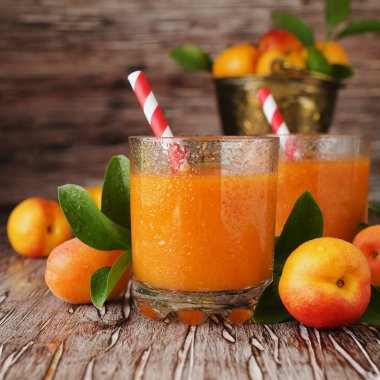 Taze kayısı suyu cam ahşap masa, seçici odak üzerinde