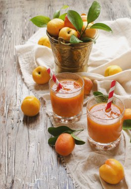 Taze kayısı suyu cam ahşap masa, seçici odak üzerinde