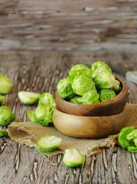 Green raw Brussels sprouts in wooden bowl , selective focus — Stock Photo, Image