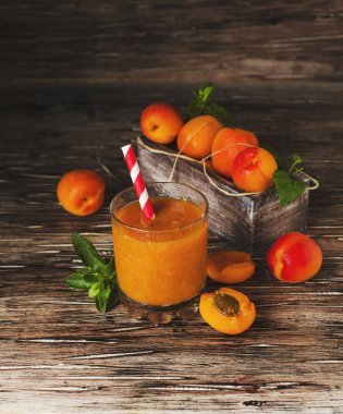 Taze kayısı suyu cam ahşap masa, seçici odak üzerinde