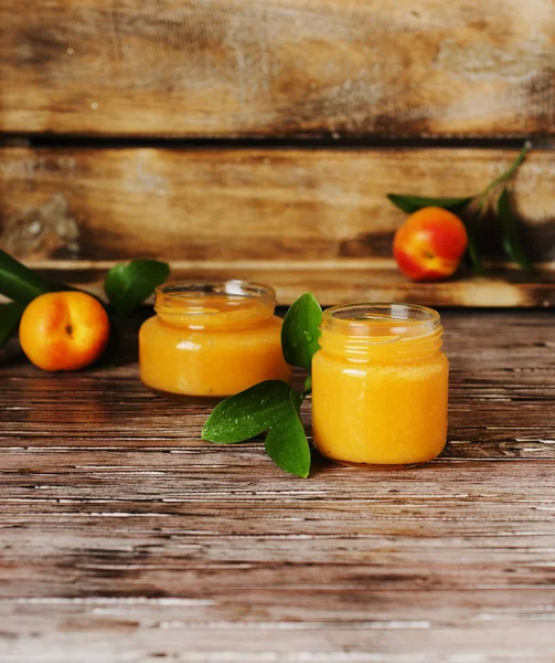 Apricot jam in small glass jars with fruits, selective focus — Stock Photo, Image