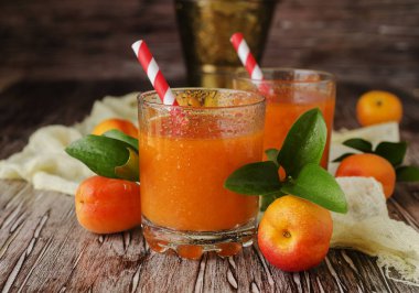 Taze kayısı suyu cam ahşap masa, seçici odak üzerinde