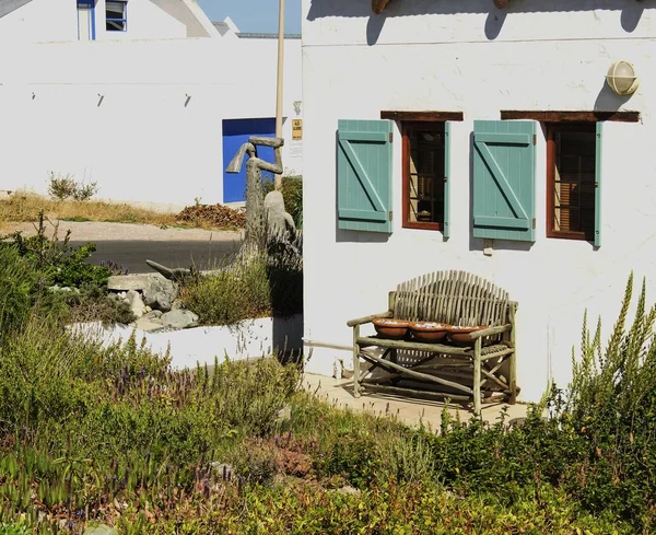 Old wooden bench standing next to fishermen's white houses — Stock Photo, Image