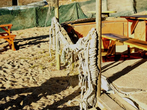 Old fishing net hanging on a wooden fence — Stock Photo, Image