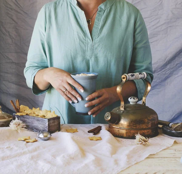 Ženské ruce držící šálek kakaa nad jídelní stůl, Selektivní ostření — Stock fotografie