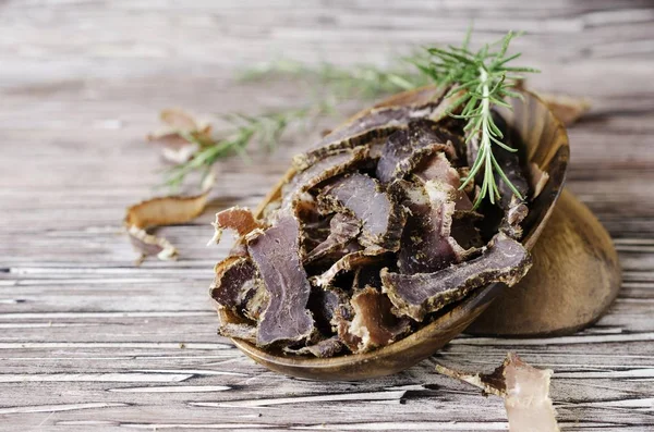 Carne batida, vaca, veado, besta selvagem ou biltong em tigelas de madeira em uma mesa rústica — Fotografia de Stock