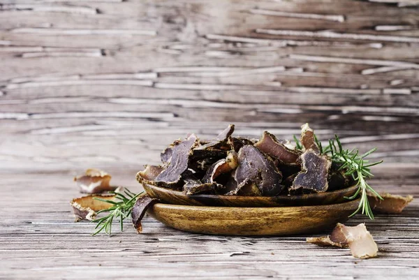 Jerked meat, cow, deer, wild beast or biltong in wooden bowls on a rustic table — Stock Photo, Image
