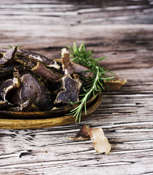 Rukte vlees, koe, hert, wild beest of biltong in houten schalen op een rustieke tafel — Stockfoto