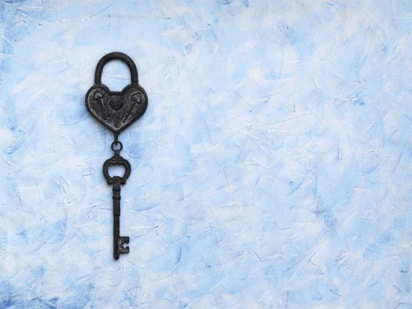 Iron key from the lock lying on wooden vintage background, top view — Stock Photo, Image