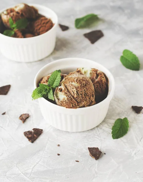 Helado de menta de chocolate en cuencos blancos con trozos de chocolate y hojas de menta en una mesa de mármol —  Fotos de Stock
