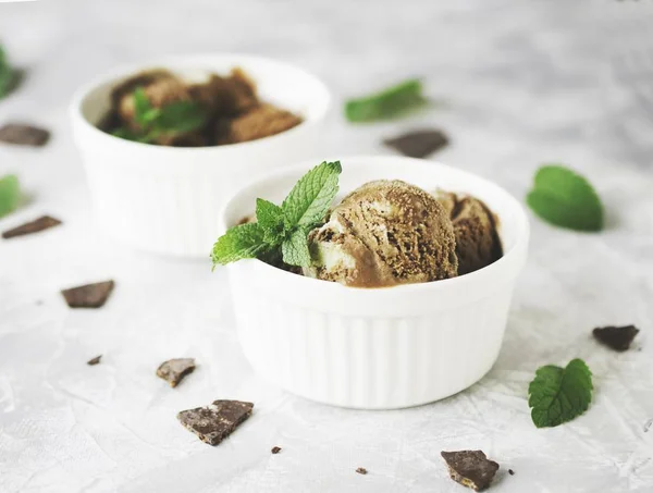 Helado de menta de chocolate en cuencos blancos con trozos de chocolate y hojas de menta en una mesa de mármol —  Fotos de Stock