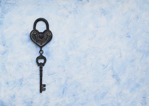Iron key from the lock lying on wooden vintage background, top view — Stock Photo, Image