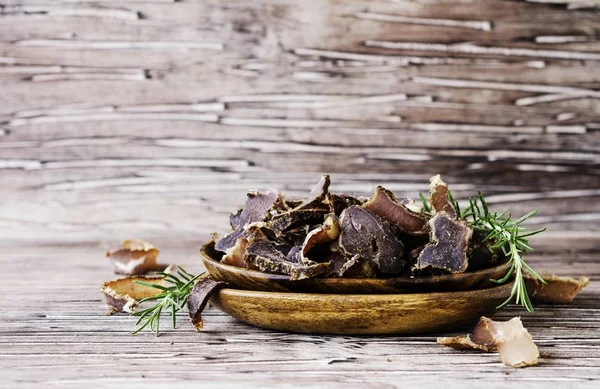 Jerked meat, cow, deer, wild beast or biltong in wooden bowls on a rustic table — Stock Photo, Image