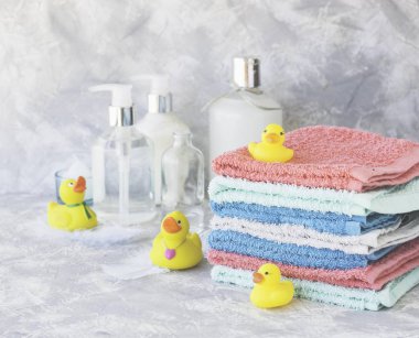 Sarı lastik banyo ördekleri beyaz mermer arka plan, metin, seçici odak için yer ile havlu yığını