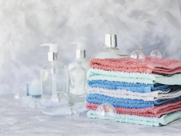 Pila de toallas para botellas de baño sobre un fondo de mármol blanco, espacio para el texto, enfoque selectivo — Foto de Stock