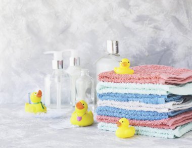 Sarı lastik banyo ördekleri beyaz mermer arka plan, metin, seçici odak için yer ile havlu yığını