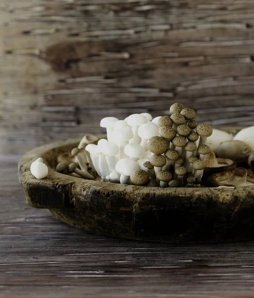 Cogumelos chineses brancos e marrons em um fundo de madeira, foco seletivo — Fotografia de Stock