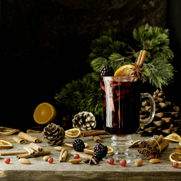 Glas Glühwein für das neue Jahr mit Zutaten zum Kochen, Nüsse und Weihnachtsdekoration — Stockfoto