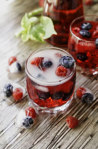 Sommerbeeren-Limonade mit gefrorenen Beeren auf einem rustikalen Holztisch, selektiver Fokus — Stockfoto