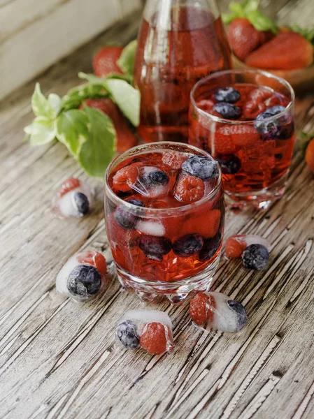 Sommerbeeren-Limonade mit gefrorenen Beeren auf einem rustikalen Holztisch, selektiver Fokus — Stockfoto