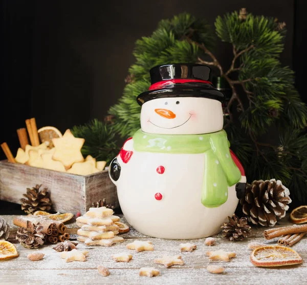 圣诞姜饼星级与雪人站在一张小木桌，选择性焦点上一罐 — 图库照片