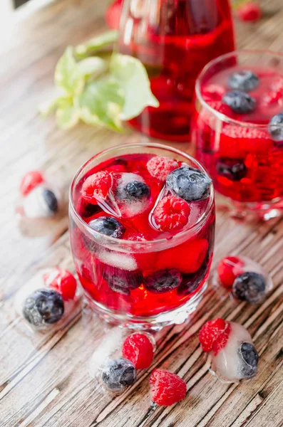 Summer berry lemonade with frozen berries on a wooden rustic table, selective focus — Stock Photo, Image