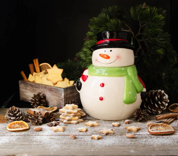 Natal biscoitos de gengibre estrela com um frasco de boneco de neve em uma mesa de madeira, foco seletivo — Fotografia de Stock