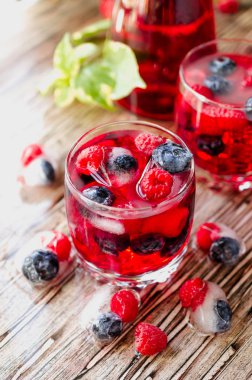 Yaz berry limonata bir masada ahşap rustik, seçici odak Dondurulmuş çilek ile