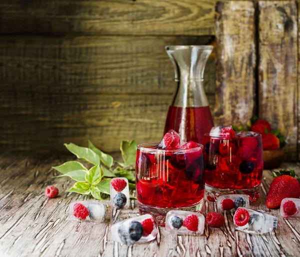 Sommerbeeren-Limonade mit gefrorenen Beeren auf einem rustikalen Holztisch, selektiver Fokus — Stockfoto