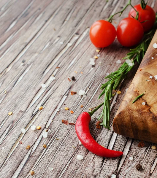 Red hot chili pepper on a wooden table with spices, selective focus — Stock Photo, Image