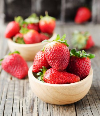 seçici odak rustik bir masada ahşap bir kase kırmızı olgun çilek