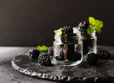 bir cam kavanoza olgun böğürtlen kahvaltı rustik bir tabloda, seçici odak