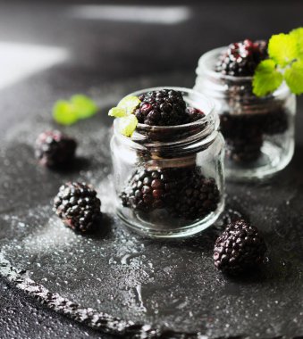 bir cam kavanoza olgun böğürtlen kahvaltı rustik bir tabloda, seçici odak