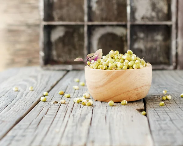Sementes vegetarianas germinadas em uma tigela de madeira em uma mesa rústica, foco seletivo — Fotografia de Stock