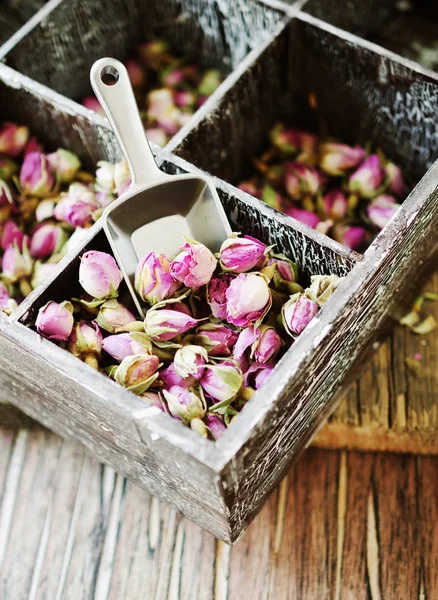 Небольшие сухие почки из роз, чай, каркаде, в деревянной коробке, избирательный фокус — стоковое фото