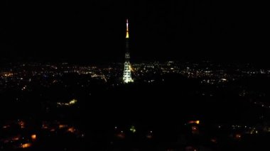 Ukrayna, Lviv 'deki Tv Kulesi ve şehir ışıklarının gece görüşü. 4k drone kamerasından çekilmiş..