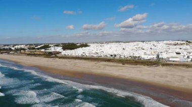 Okyanusun 4k hava aracı sahnesi. Kumsalı ve eski kasabanın binalarını keşfedin. Plaj ve şehir manzarası