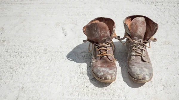 Old brown work boots covered in concrete