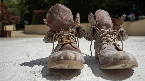 Old brown work boots covered in concrete