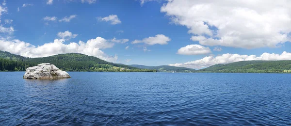 Almanya 'da, Kara Orman' da Schluchsee Gölü 'nde kayalar. Yazın mavi ve beyaz gökyüzü ile bir panorama olarak çekilir.. 