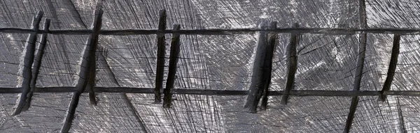 Abstract artistic structure in dark wood with charred notches as panoramic closeup
