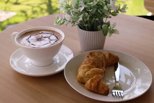 Croissant és kávé az asztalon — Stock Fotó