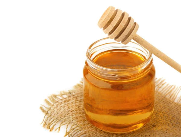 Honey in jar with a wooden spoon isolated on white background — Stock Photo, Image