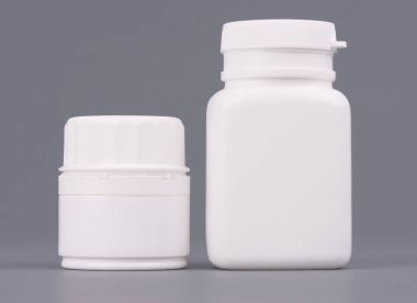 Boş büyük ve orta boy tıp beyaz plastik ambalaj şişe kozmetik, vitaminler, haplar veya kapsül. Gri arka plan üzerinde ambalaj