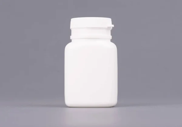 空白的大型医药白色塑料包装瓶化妆品、 维生素、 药片或胶囊。包装对灰色背景 — 图库照片