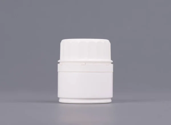 Порожня середнього розміру медицина біла пластикова упаковка пляшок для косметики, вітамінів, таблеток або капсул. Упаковка на сірому фоні — стокове фото