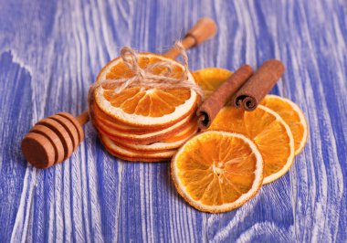 Dilim portakal ve tarçın, mavi ahşap arka plan üzerinde kuru. Aromatik baharatlar. Noel süsleri.