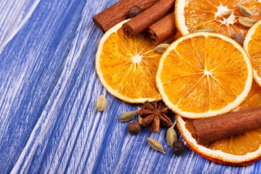 Portakal, tarçın, yenibahar ve kakule mavi ahşap arka plan üzerinde kuru dilim