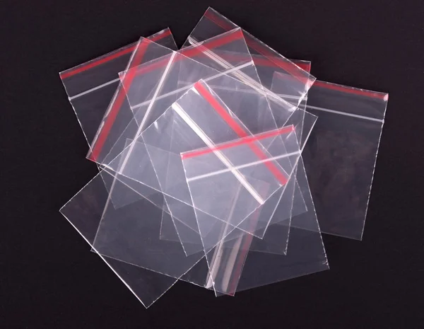 Kunststoff transparente Reißverschlusstasche auf schwarzem Hintergrund. Blockverpackung mit Reißverschluss. leere Polyethylen-Reißverschluss-Verpackung. Klares Rudel — Stockfoto