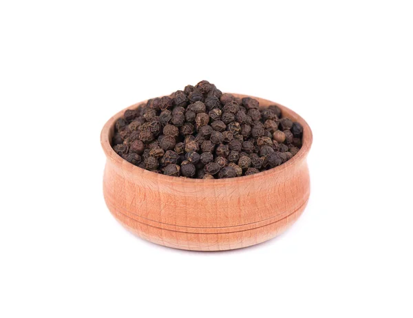 Grãos de pimenta preta isolados sobre fundo branco. Peppercorn em uma tigela de madeira isolada em branco . — Fotografia de Stock